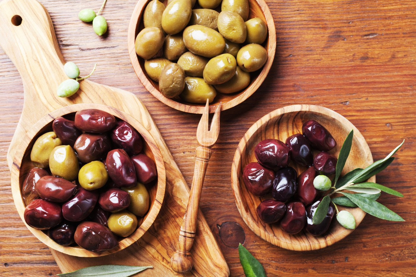 Homemade green black olive tapenade is delicious on tomato salad
